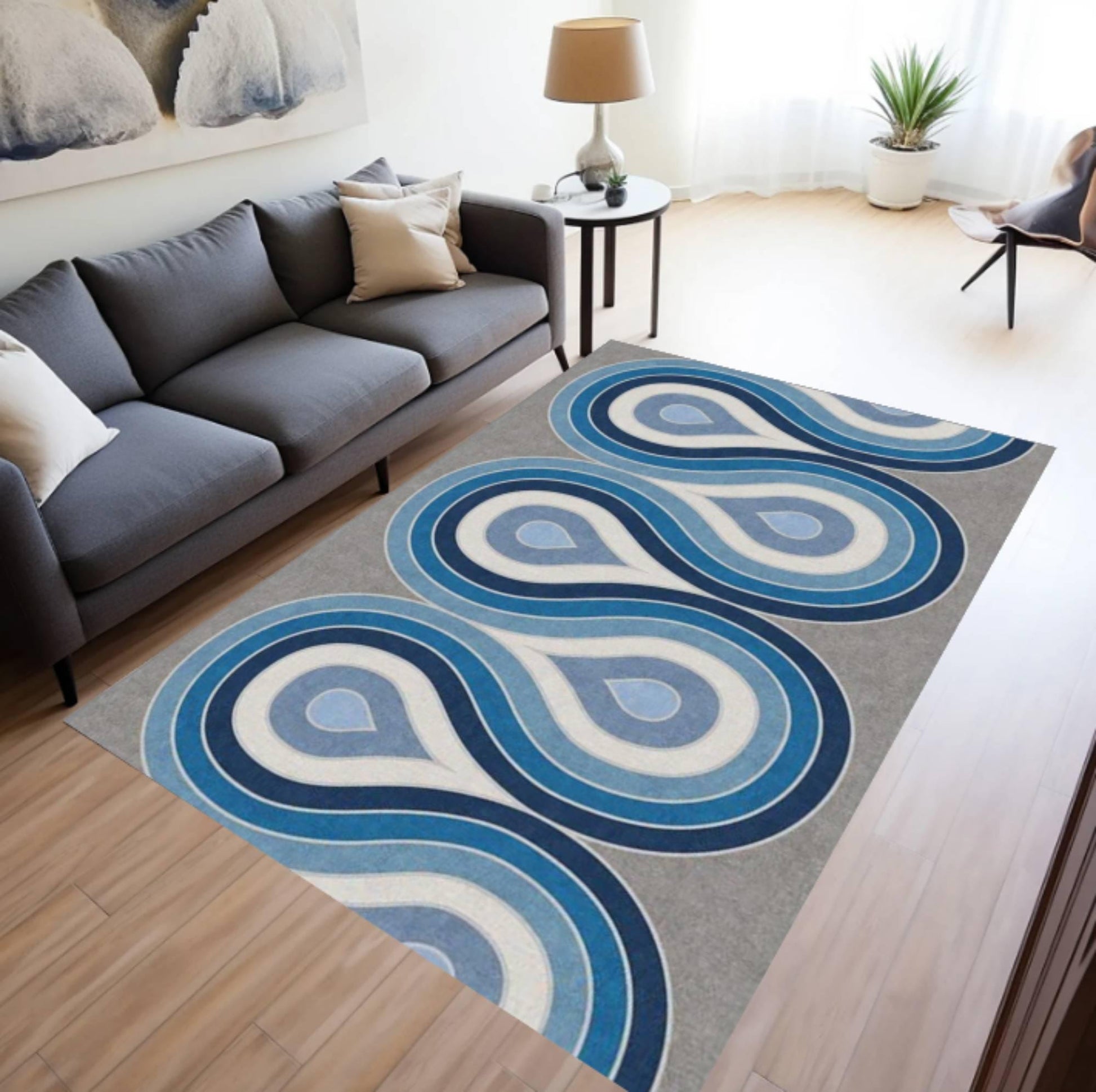 Living room with a blue and gray patterned rug, gray sofa, and side table.