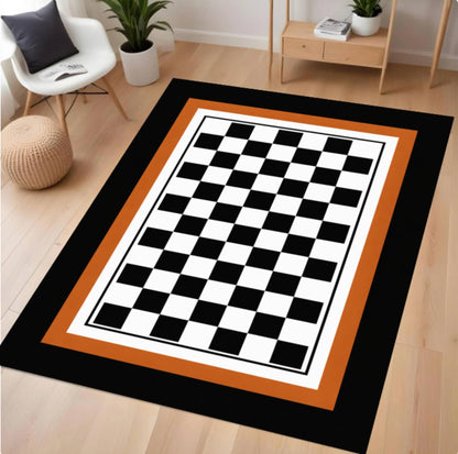 Checkered rug with black, white, and orange pattern on a wooden floor.