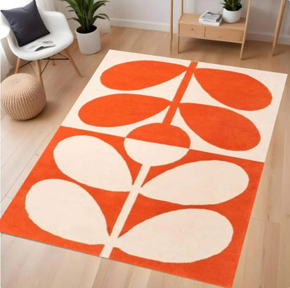Orange and white patterned rug on a wooden floor with a modern chair and decor in the background.