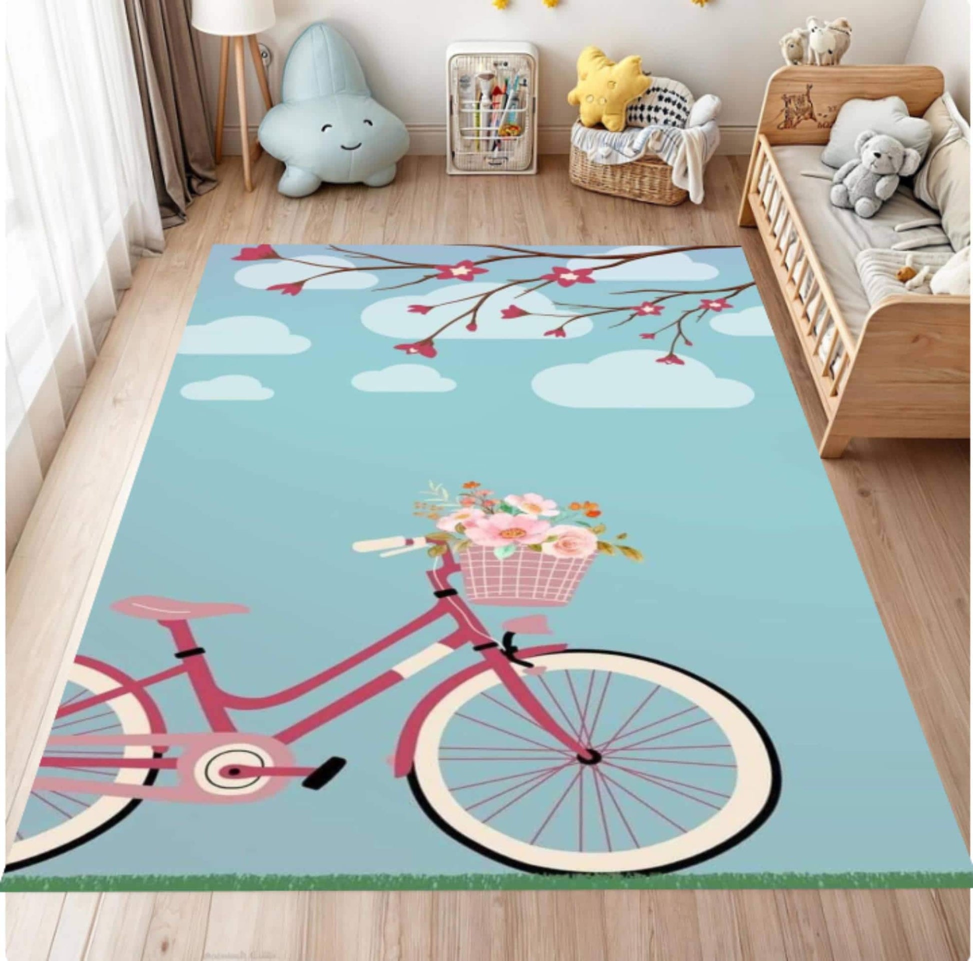 A rectangular area rug with a whimsical bicycle and cherry blossom design, styled in a child's bedroom on a light wood floor next to a wooden bed.