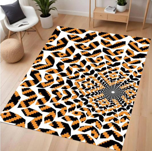 A rectangular area rug with a bold black, orange, and white geometric pattern, displayed on a light wood floor in a modern living room setting.