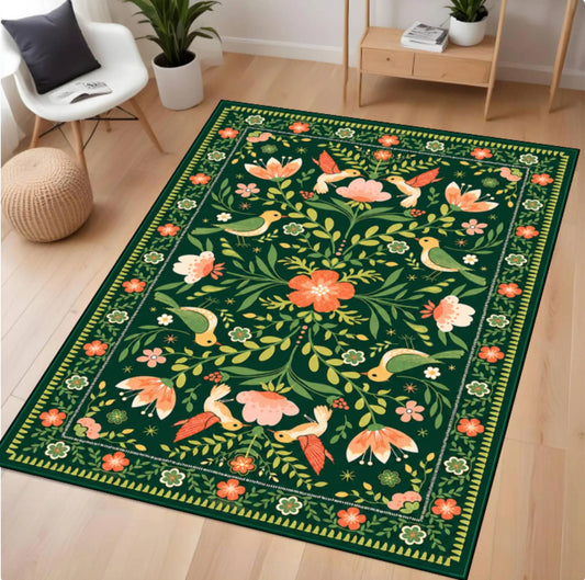 A rectangular area rug with a dark green background and a colorful botanical and bird pattern, shown on a light wood floor in a modern living room setting.