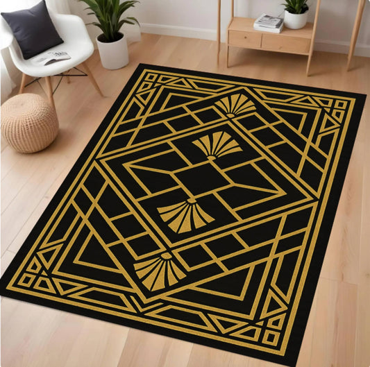 A rectangular area rug with a black background and a bold gold Art Deco geometric pattern, shown on a light wood floor in a modern living room setting.