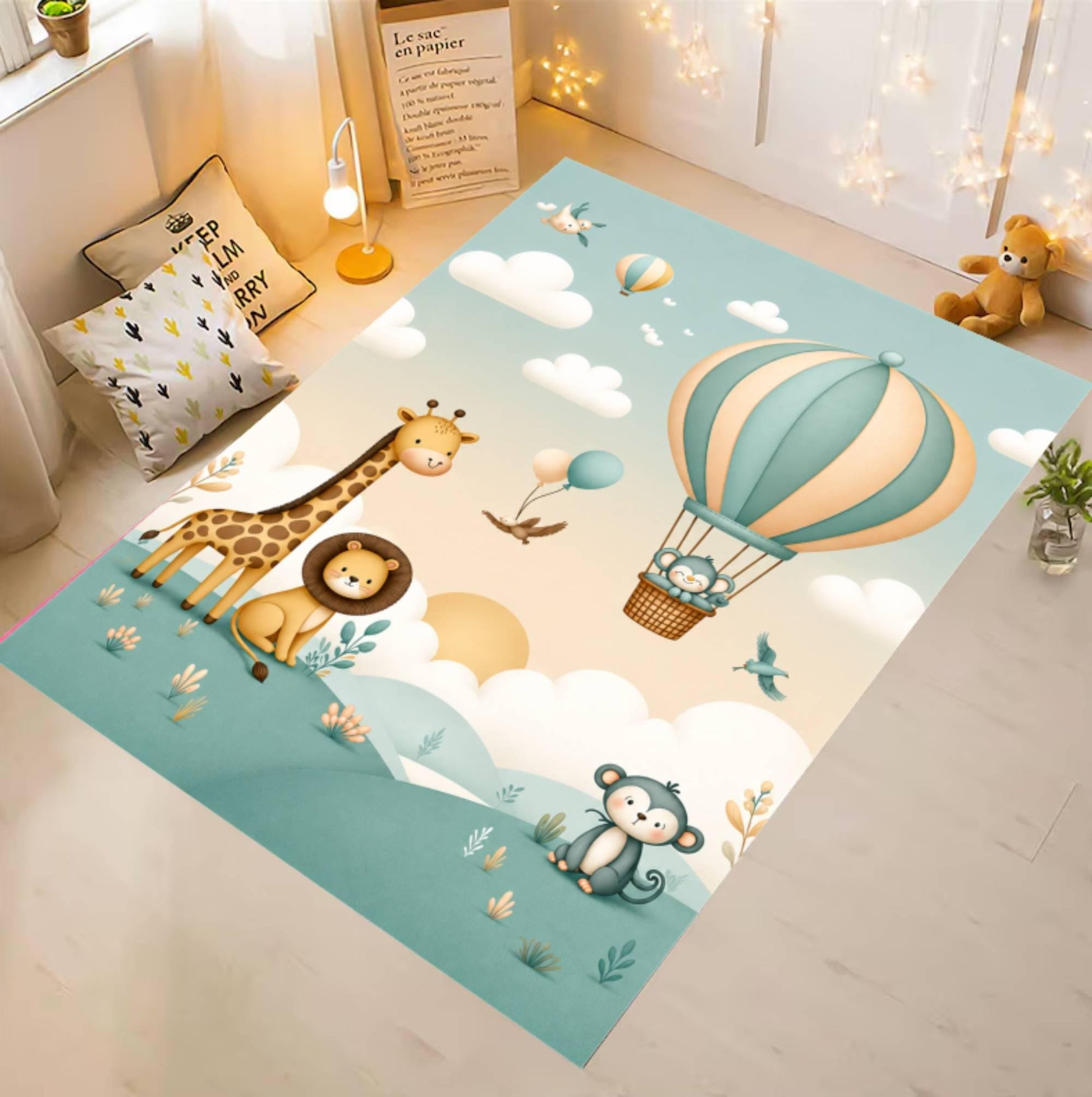 A rectangular children's area rug laid on a light wood floor in a styled nursery corner. The rug features a pastel illustration with a hot air balloon, clouds, a giraffe, lion, monkey, and small plants.