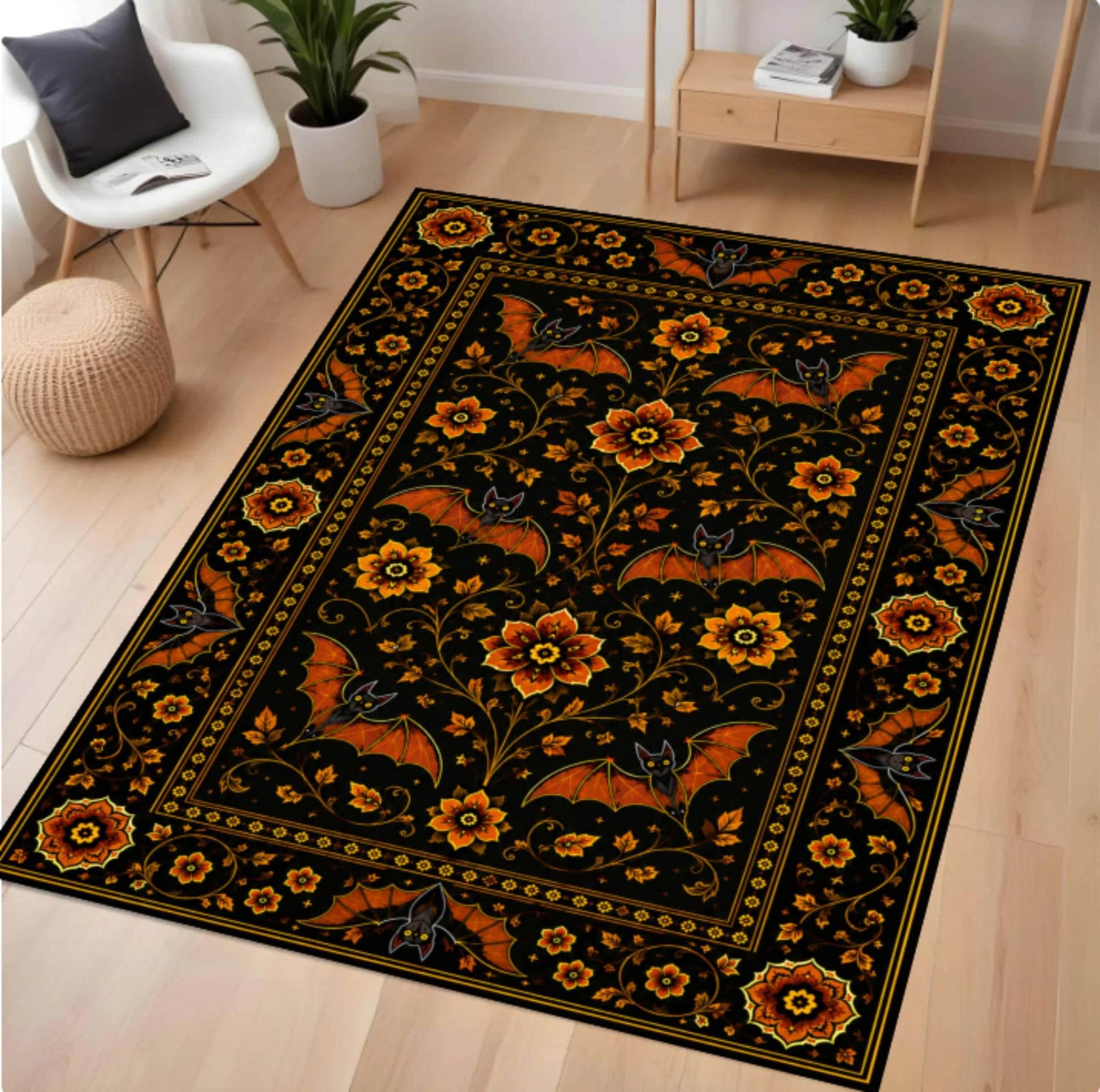 A rectangular area rug with a black background and an ornate floral and bat pattern in orange, yellow, and gold, shown on a light wood floor in a modern living room setting.