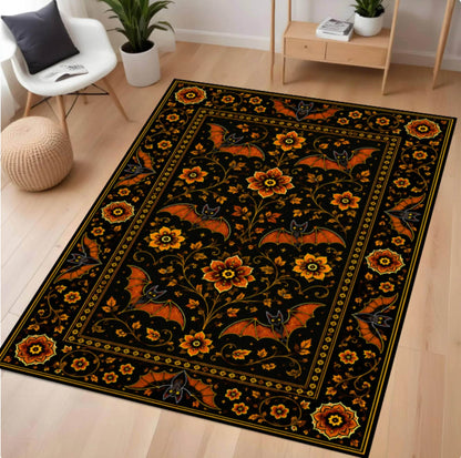 A rectangular area rug with a black background and an ornate floral and bat pattern in orange, yellow, and gold, shown on a light wood floor in a modern living room setting.