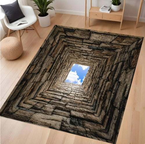 A square area rug with a 3D-effect perspective design showing a stone wall tunnel leading up to a blue sky with white clouds, displayed on a light wood floor in a modern living room setting.